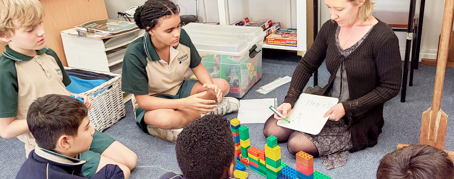 DEN educator doing floor work with the learners